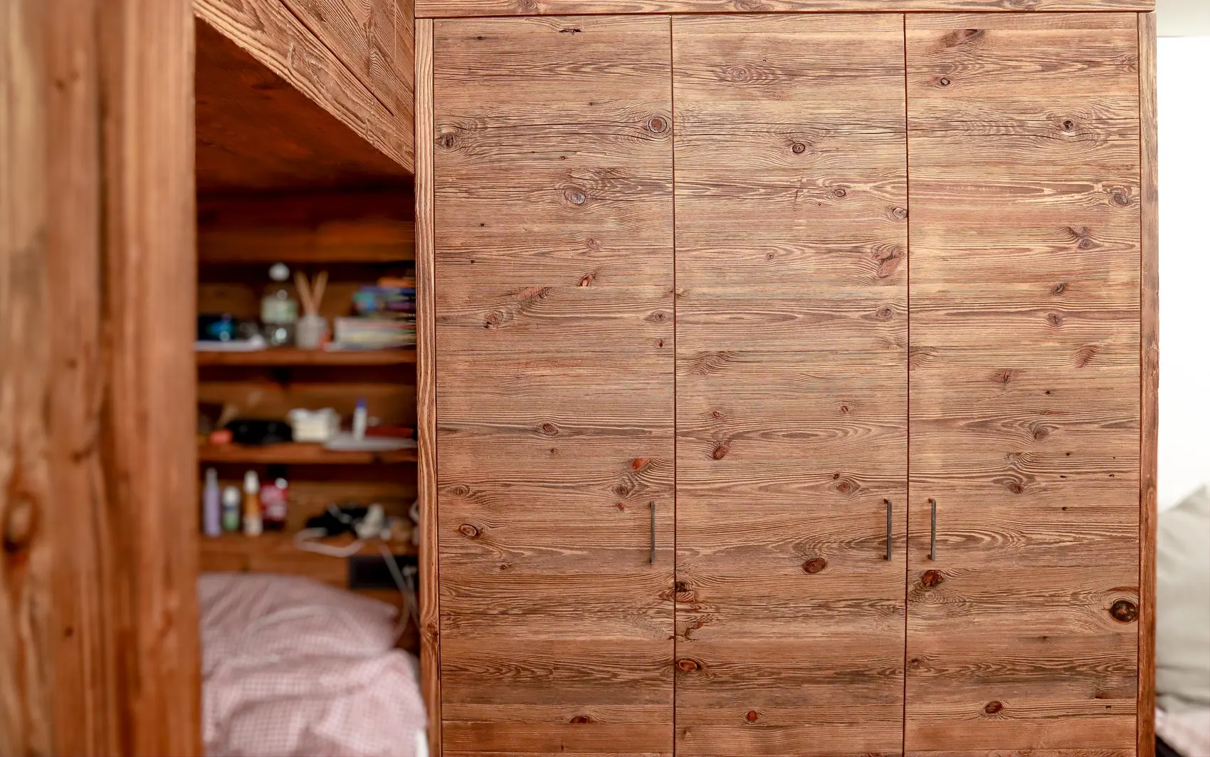 Schlafzimmer mit Kleiderschrank in dunkler Holzoptik.