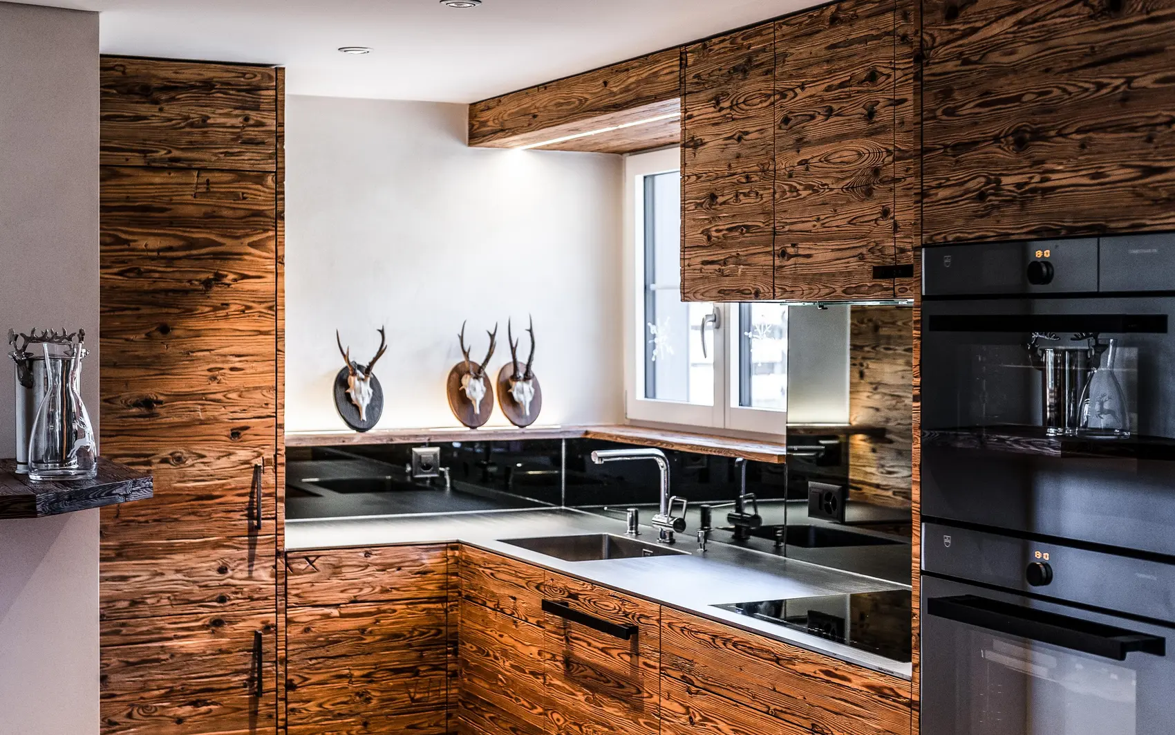 Holzküche mit Küchengeräten und schwarzen Elementen