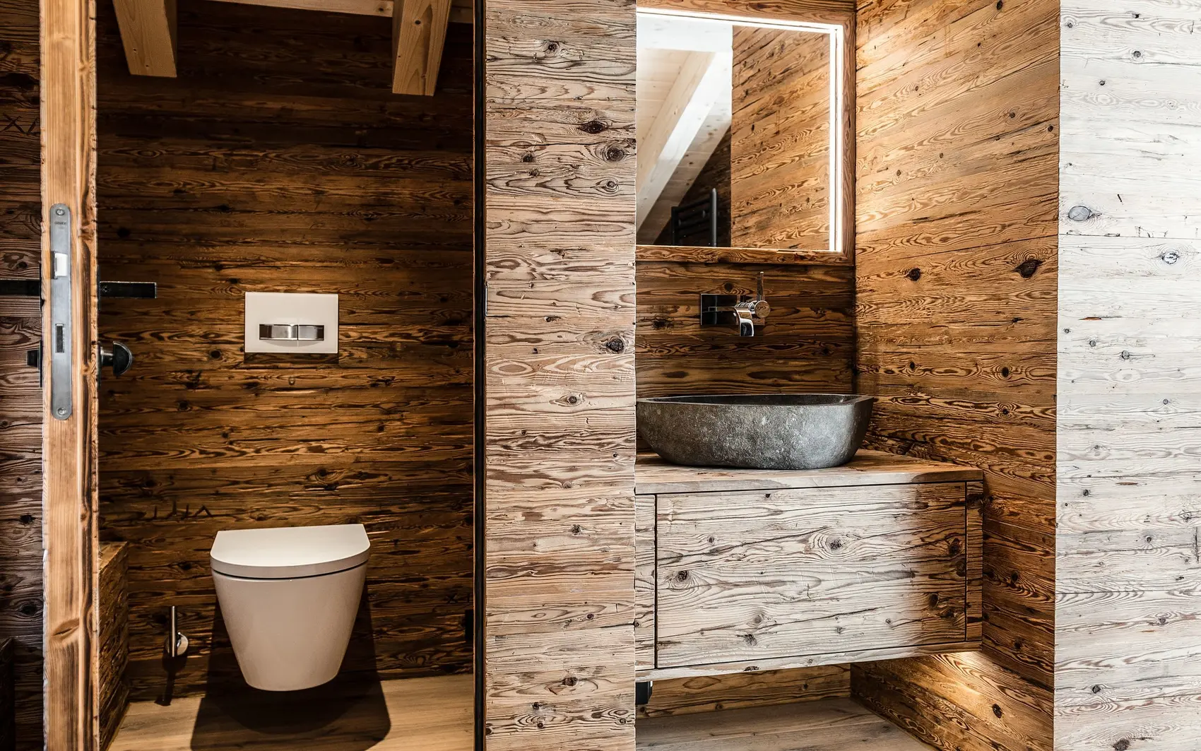 Badezimmer in kompletter Holzoptik und Steinwaschbecken.