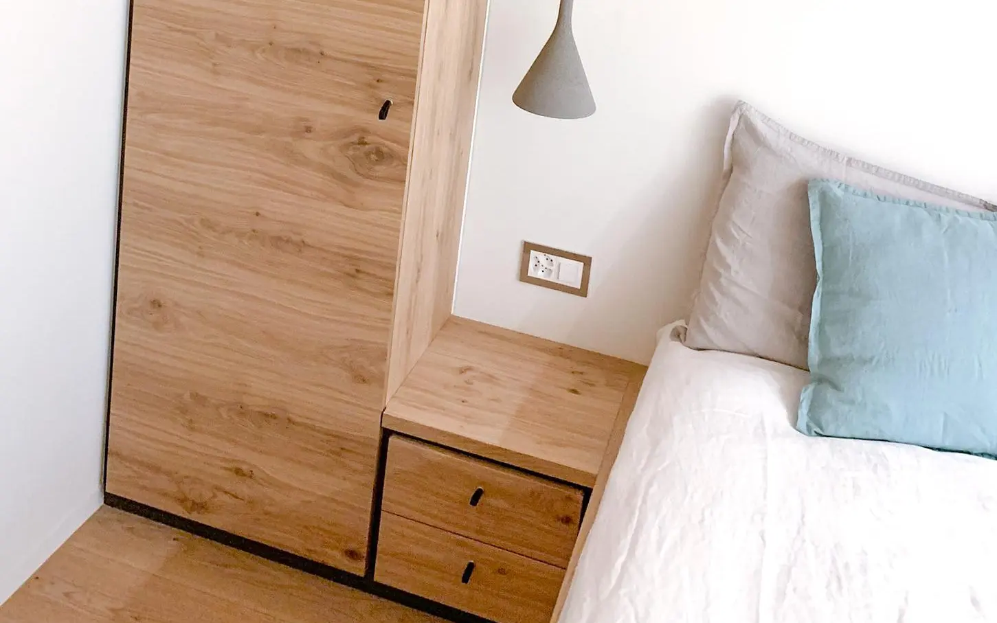 Nachttisch und Schrank mit schwarzen Ledergriffen.