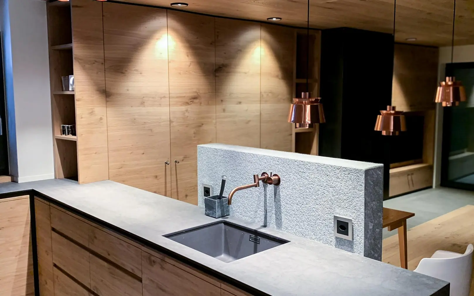 Küche mit hellem Holz und Steinplatten.