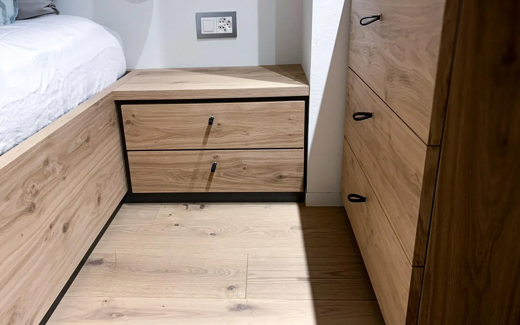 Nachttisch und Kommode mit Ledergriff an den Schubladen.