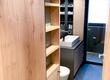 Badezimmereinrichtung aus Holz mit schwarzen Lederriemen als Schubladengriffe.